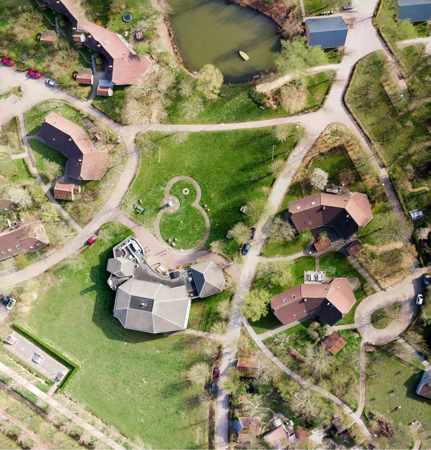 Luchtfoto van Overkempe met woonhuizen, paden, grasvelden en een vijver
