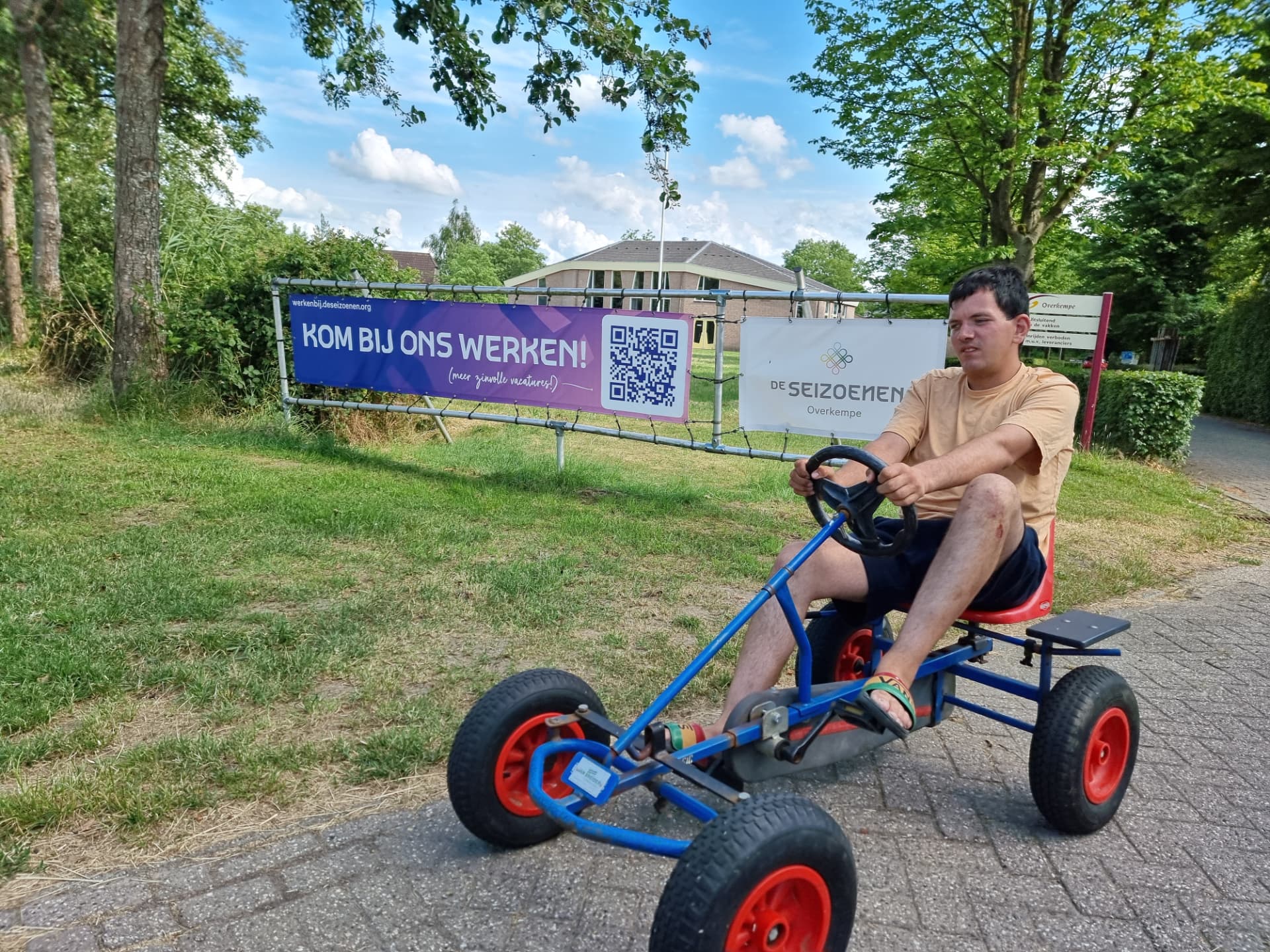 Bewoner rijdt op een skelter over het pad langs het grasveld van Overkempe
